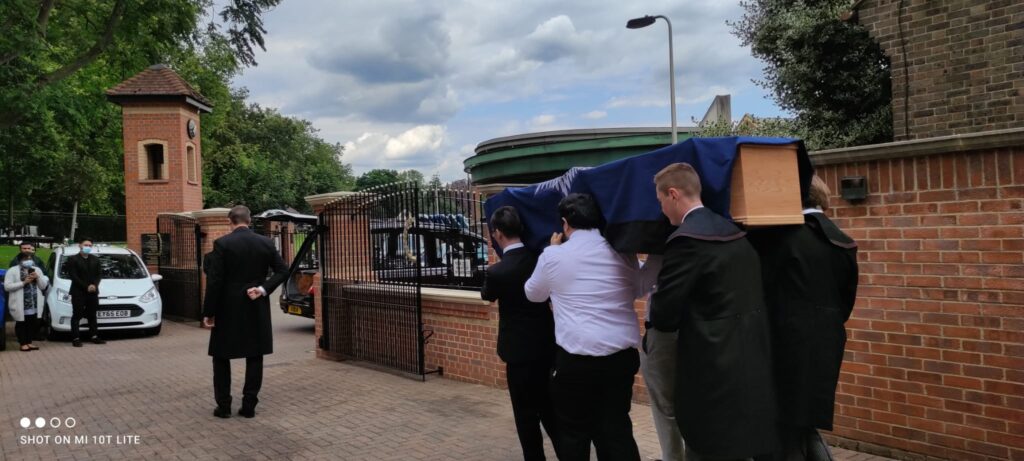 Offerings of rice and water during Hindu cremation rituals in the UK.